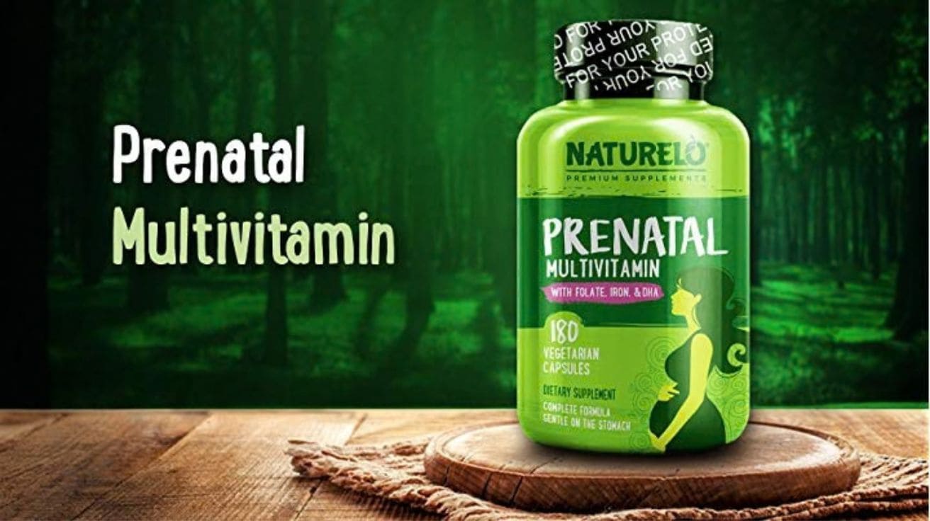 Naturelo Prenatal Multivitamin bottle with folate, iron and DHA placed on wooden surface with green natural background, pregnancy dietary supplement capsules for maternal health.